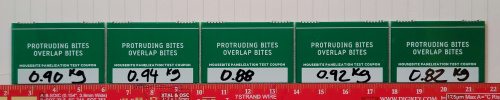 Tabs snapped off from the small PCBs are lined up against a ruler for scale