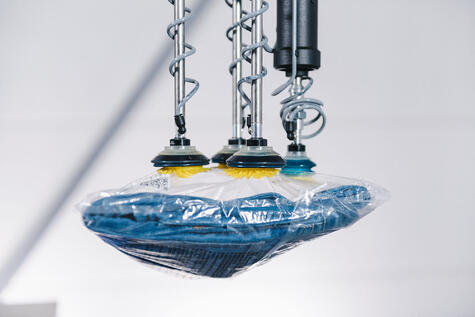 Packed fashion apparel being picked by a robotic vacuum gripper