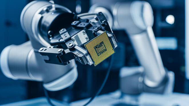 Robotic gripper holding a pcb in an assembly application.