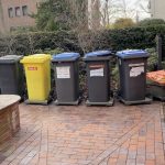 This train of trash bins moves to the curb with the press of a button
